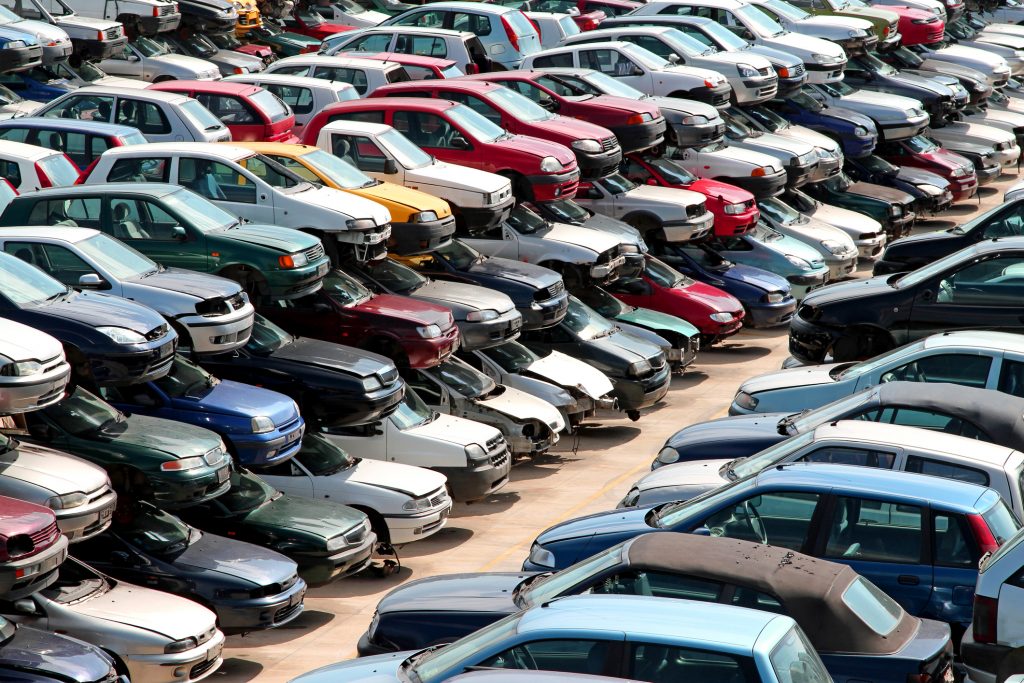 Scrapped cars stacked up on racks in a scrap yard