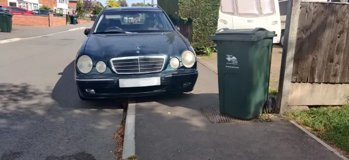 Dirty Mercedes parked on the road